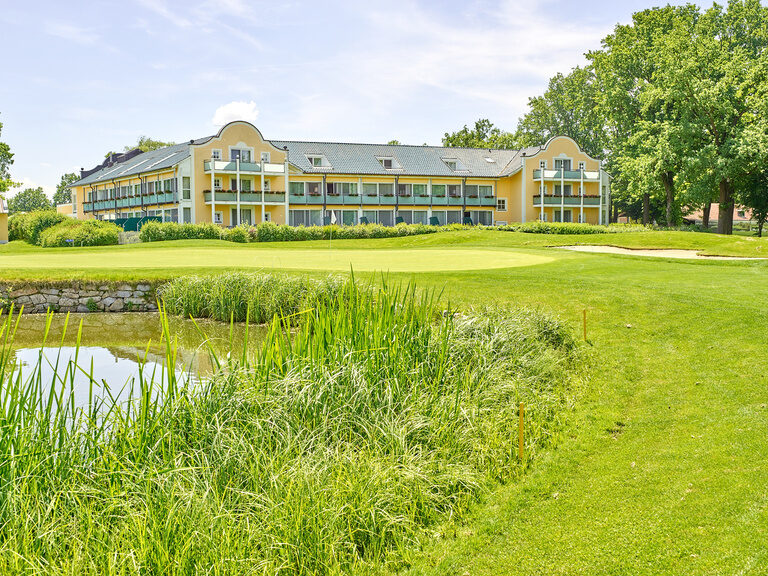 Außenansicht vom Hotel bei Bad Griesbach mit gelbem Auenanstrich und großer grüner Wiese.